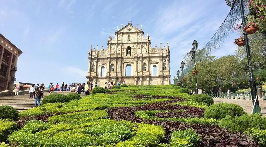 大三巴牌坊全景，游客在牌坊前的台阶上拍照留念